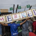 migrants-hold-a-banner-reading-merkel-in-front-of-a-barrier-at-the-border-with-hungary-near-the-village-of-horgos-2