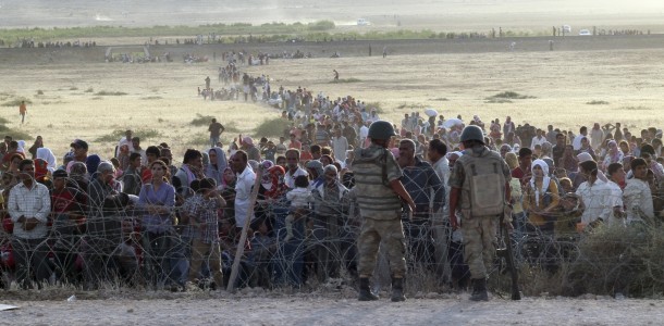 turkish-soldiers-stand-guard-syrian-refugees-wait-behind-border-fences