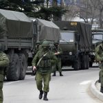 armed-servicemen-wait-near-russian-army-vehicles-outside-a-ukrainian-border-guard-post-in-the-crimean-town-of-balaclava