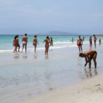 capitanas-beach-italy-august-25-unidentified-people-in-white-beach-with-blue-crystal-sea-and-waves-in-summertime-on-august-25-2010-in-capitana-italy