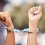 activist-woman-hands-fist-handcuffs-and-social-justice-protest-of-women-protesting-outdoor-hand-view-of-empowerment-black-lives-matter-or-iran-sexual-assault-fight-for-human-rights-with-power